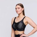 Model met blonde haren draagt een zwarte sportbeha met geometrisch patroon, Prima Donna logo.