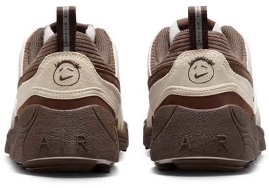Achterkant van bruine, witte en lichtblauwe sneakers met logo's en een glimlachend gezichtje.