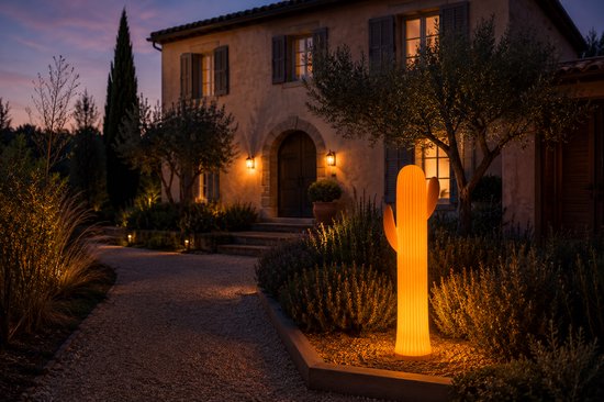 Oranje cactuslamp verlicht de oprit van een landhuis.