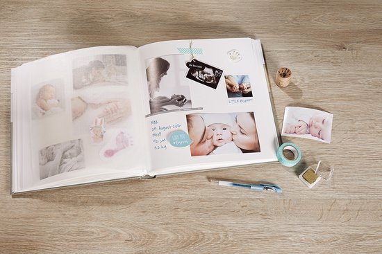 Open babyalbum met foto's van baby's, voetafdrukken en een echofoto. Met decoratiemateriaal.