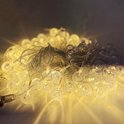 Une guirlande lumineuse enroulée de 50 ampoules rondes et transparentes avec effet filament, avec des rayons lumineux doux et chauds.