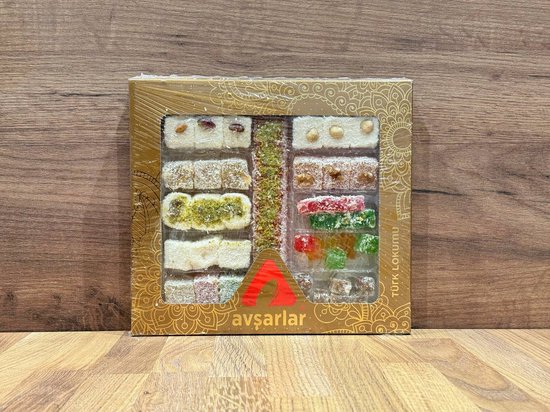 Gouden doos met diverse soorten Turks fruit, met zichtbare noten en kokos. Text met "TÜRK LOKUMU" en "AVŞARLAR".