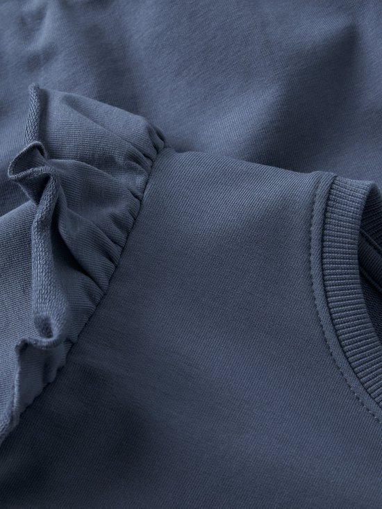 Detail van de ruches op de schouder van een blauwe sweater.