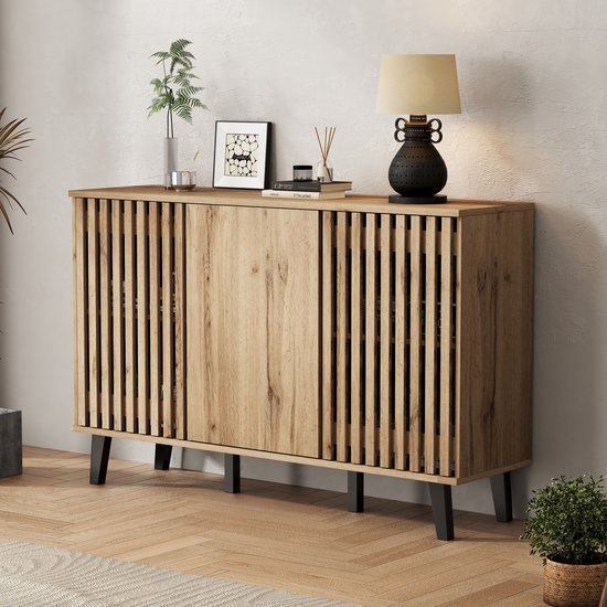 Buffet en bois avec façade à persiennes, trois portes et pieds noirs, dans un salon.