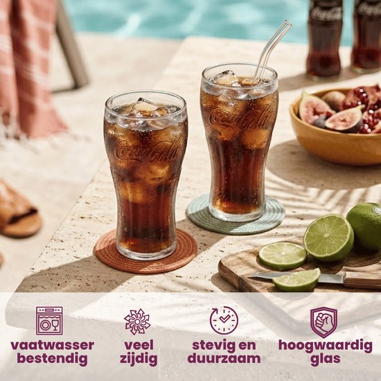 Deux verres Coca-Cola remplis sur des sous-verres, avec des rondelles de citron vert, des figues et des bouteilles de cola en arrière-plan.