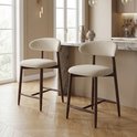 Twee beige barkrukken met houten poten en een gebogen rugleuning in een lichte kamer.