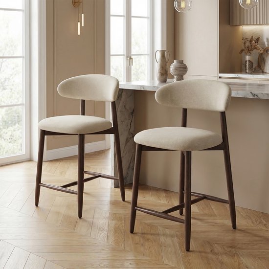 Twee beige barkrukken met houten poten en een gebogen rugleuning in een lichte kamer.