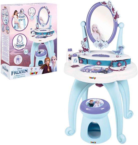De verpakking van een Smoby Frozen speelgoedkaptafel. Toont de kaptafel, een meisje, de '2-in-1' functie en accessoires.