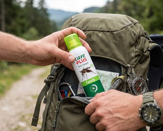 Handen plaatsen Care Plus Anti-Insect Family aerosol in een rugzak. Groene dop, witte bus met rode 'care PLUS'. Afbeelding van mug en '6h'.