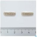Twee doorzichtige capsules, gevuld met kleine korrels, naast een meetlat.