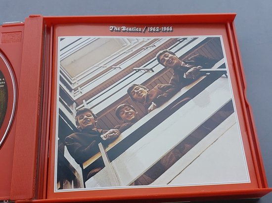 Een open cd-hoes met de rode binnenkant. Toont de vier Beatles op een trap, kijkend naar boven.