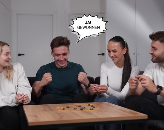 Vier vrienden vieren een overwinning tijdens het spelen van een spel met magneten. De tekstballon zegt: 'JA! GEWONNEN.'