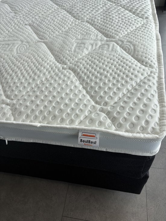 Witte matras met een gewatteerd, ruitvormig patroon en een BestRest Bedden label.