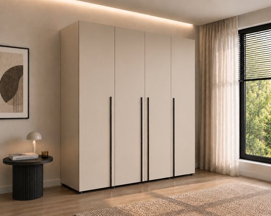 Beige kledingkast met vier deuren en zwarte handgrepen, zicht op een slaapkamerraam.