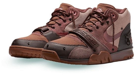 Paar bruine Nike Air Trainer 1 SP Travis Scott sneakers met "CACTUS CORPORATION" band.
