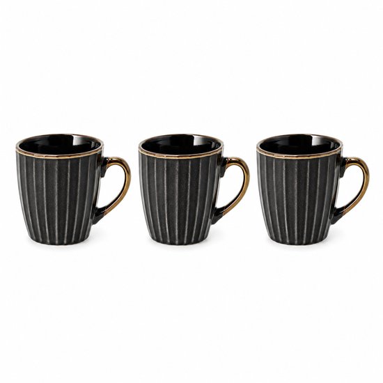 Drie zwarte mokken met gouden oor, op een rij. De mokken hebben verticale ribbels.
