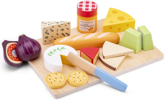 Planchette de fromage en bois avec pain, fromage, figue, pot de chutney et couteau. Un fromage avec une branche verte.
