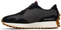 Zwarte New Balance sneaker met grijze panelen, witte zool en bruine profielzool. Tekst 'new balance' op zijkant.