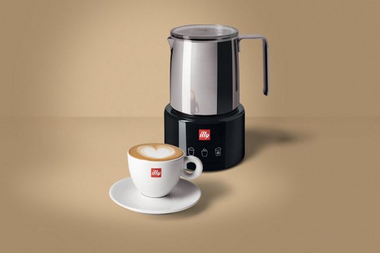 Zwarte Illy melkopschuimer met een RVS melkkan en een witte Illy kop met cappuccino, hartvormig melkschuim.