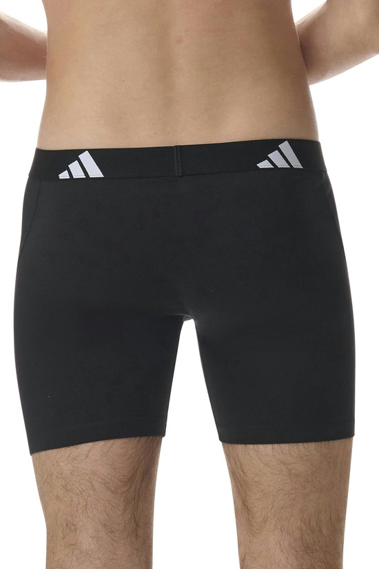 Achterkant van man in zwarte Adidas boxershorts met zwarte tailleband met Adidas logo.