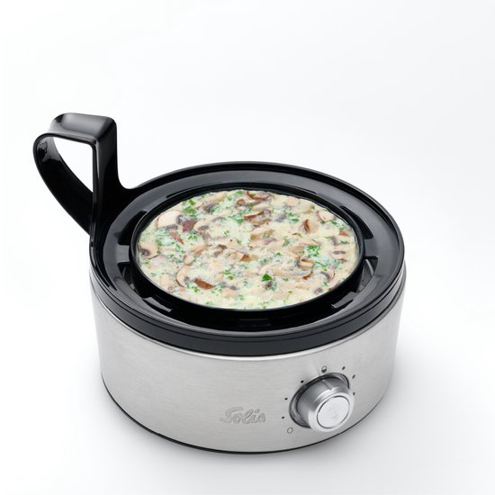 Zilverkleurige Solis eierkoker met een gerecht met paddenstoelen en kruiden, met draaiknop aan de voorkant.