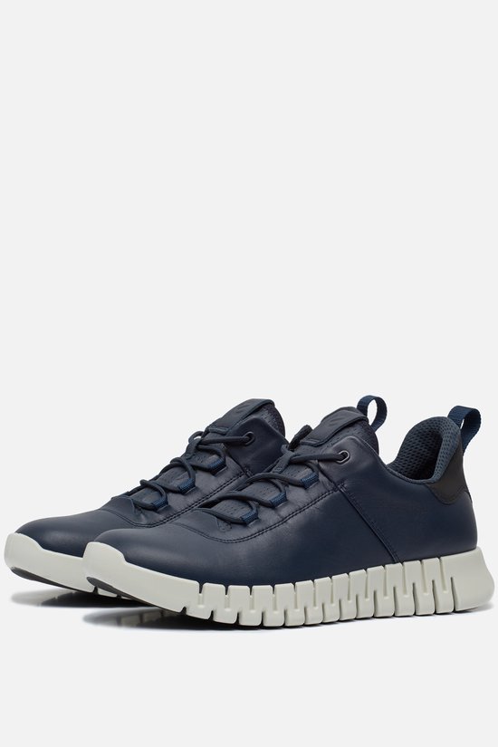 Paar donkerblauwe leren sneakers met witte, segmentale zolen en veters. Zwarte accenten op de hielen.