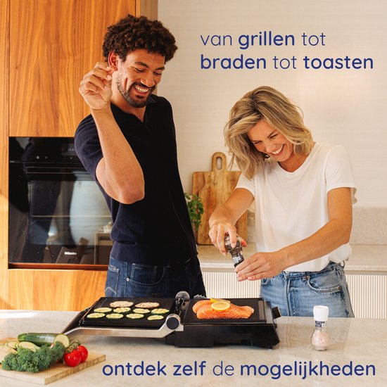 Man en vrouw lachen terwijl ze koken op een Safecourt contactgrill. De vrouw grilt zalm, de man doet iets met pepers.