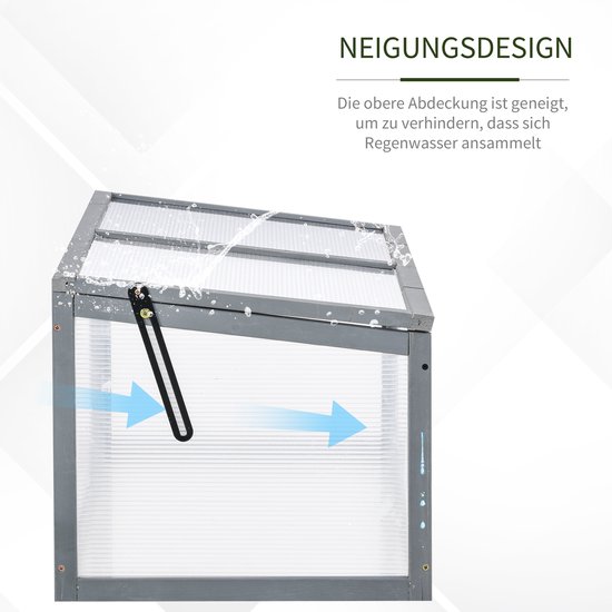 Grijze houten mini-kas met transparant polycarbonaat, waarbij het schuine deksel regenwater afvoert.