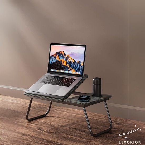 Donker houtnerf laptoptafel met laptop, mok en telefoon.