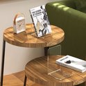 Een transparante boekensteun met een boek en een wekker op een ronde salontafel.
