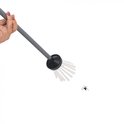Een hand houdt een grijze steel met spinnenvanger, een spin op witte achtergrond.