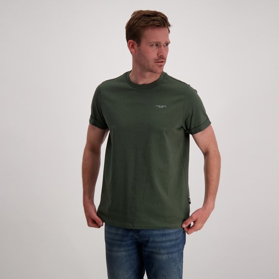 Man draagt donkergroen Cars Jeans T-shirt met korte, omgeslagen mouwen en opdruk op de linkerborst, met spijkerbroek.