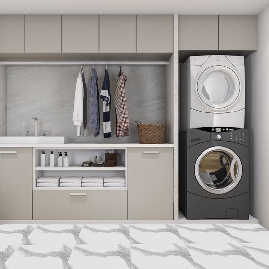 Moderne wasruimte met grijze marmeren wandtegels, beige kasten en een witte en zwarte wasmachine/droger.