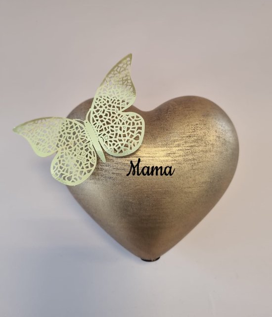 Gouden hartvormige urn met decoratieve vlinder en tekst 'Mama'.