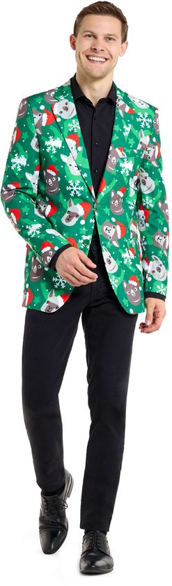 Man in groene blazer met kerstprint van lama's en sneeuwvlokken, met rode kerstmuts.