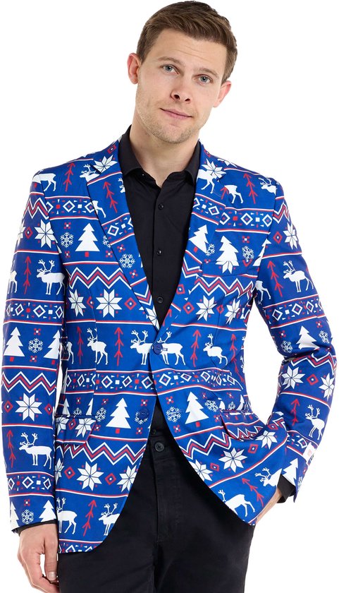Man die een blauwe blazer met kerstprint draagt. De blazer heeft een patroon van kerstbomen en rendieren.