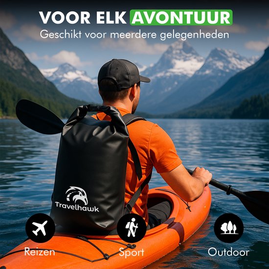 Zwarte Travelhawk drybag rugzak gedragen door een man in een oranje shirt, kajakkend op een meer met bergen op de achtergrond.