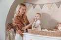 Moeder veegt baby's gezicht schoon met hydrofiel doekje met hartjes.