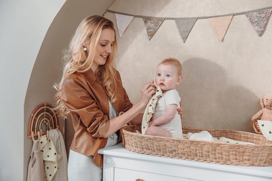 Moeder veegt baby's gezicht schoon met hydrofiel doekje met hartjes.