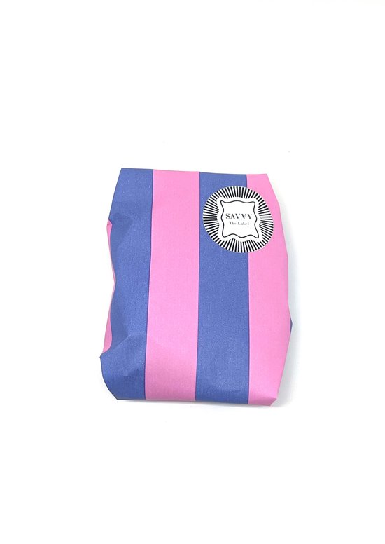 Een vierkant pakketje verpakt in roze en blauwe strepenpapier, met een sticker van Savvy the Label.