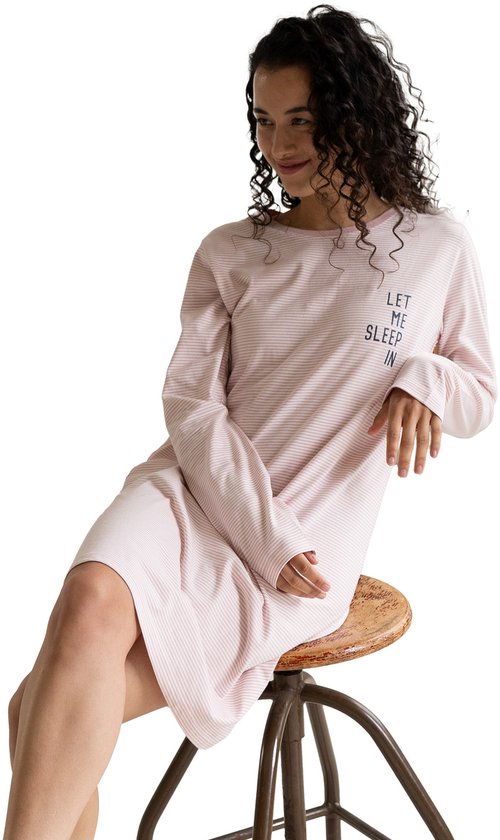 Model zittend op een krukje in een lichtroze gestreept nachthemd met de tekst 'LET ME SLEEP IN'.