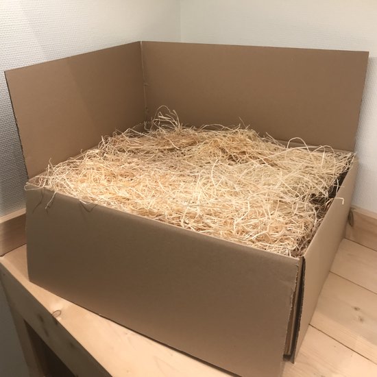 Bruine kartonnen doos gevuld met lichtgekleurde houtsnippers.