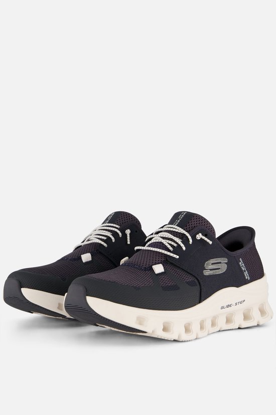 Twee donkerblauwe Skechers Slip-ins sneakers met witte veters en opvallende witte zolen.