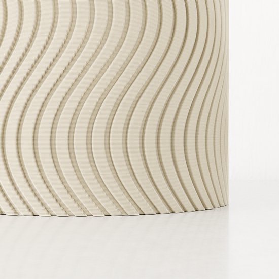 Détail du bas d'un vase crème à motif ondulé.