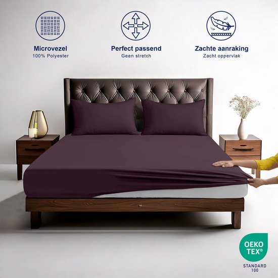 Drap-housse violet foncé sur un lit. Une main montre la surface douce.