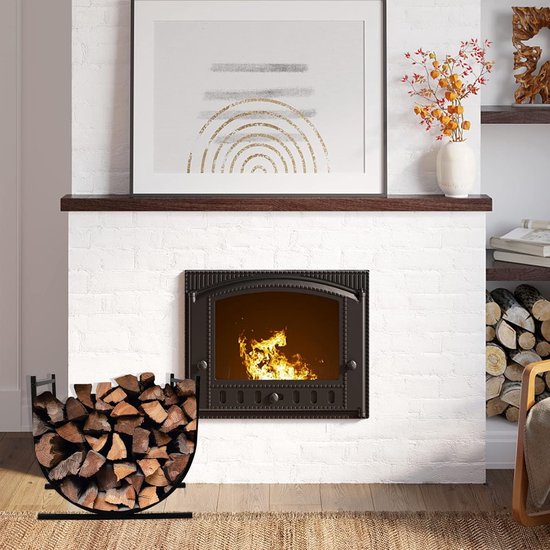 Zwarte brandhoutmand met brandhout, naast een open haard met witte bakstenen.