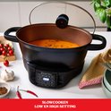 Zwarte multicooker met soep, deksel op een kier. Digitale display toont 00:30. Slowcookfunctie met low en high settings.