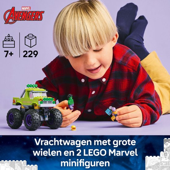 Jongen speelt met groene LEGO monster truck en minifiguren Hulk en Thanos.