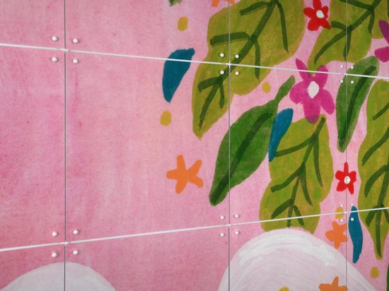 Close-up van IXXI wandsysteem met roze achtergrond en bloemdetails.