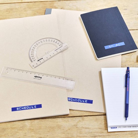 Twee mappen met de tekst 'SCHEDULE' en een zwart notitieboek met de tekst 'TO DO', gelabeld met de Dymo Omega.